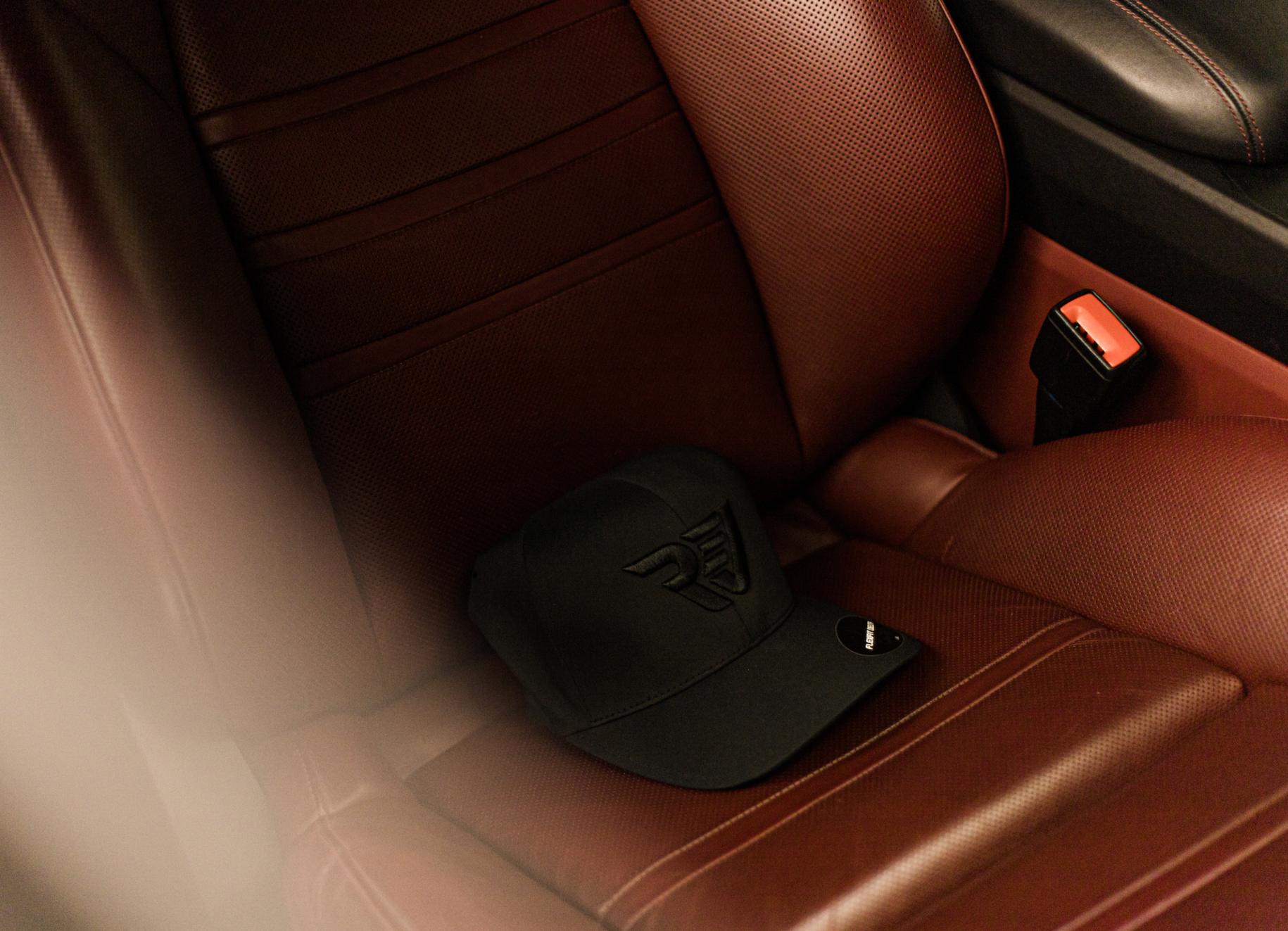 Black Rev hat on a Bordeaux Porsche seat